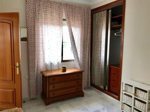 1 dormitorio con vestidor y ventana con cortinas en Calle Valenzuela 9 La Rambla, en La Rambla