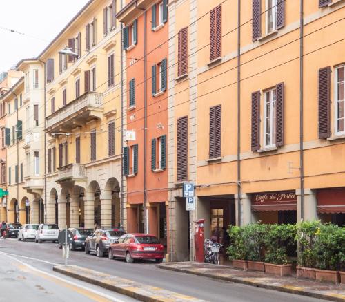 a row of buildings on a street with parked cars at BolognaRoomscom - Santo Stefano Apartments in Bologna