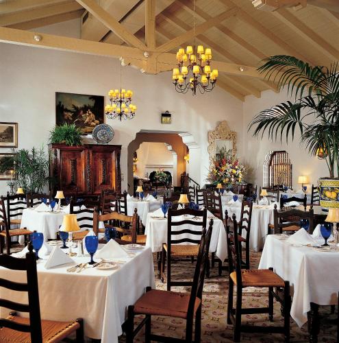a dining room with white tables and chairs at Arizona Inn in Tucson