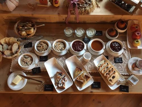 a table topped with different types of desserts and coffee at Agritur Ciasa Dò Parè in Soraga