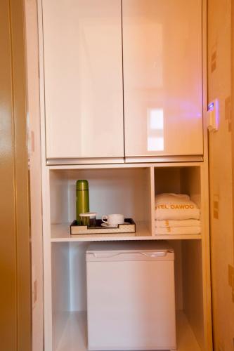 a kitchen with white cabinets and a trash can at Hotel Daewoo Inn in Seoul