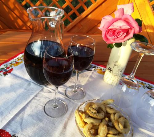 two glasses of wine and a plate of food on a table at Bungalovy Natura in Trávnica