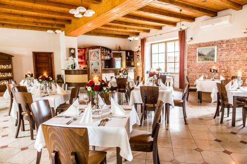 a restaurant with white tables and chairs and a brick wall at Dworek Korytków in Kamienna Wola