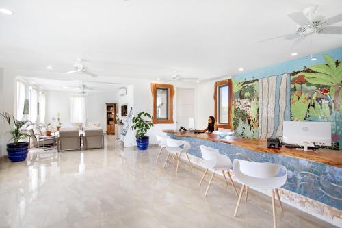 a room with a counter with white chairs and a wall at Beach View Hotel in Saint James