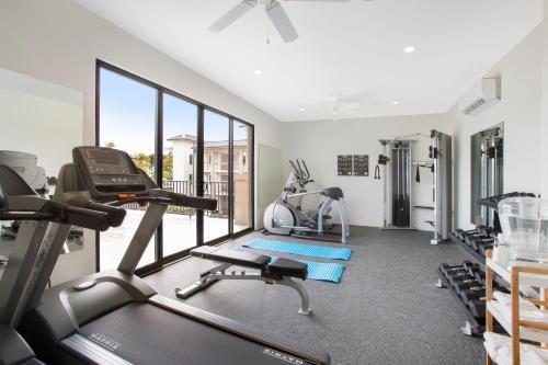 a gym with treadmills and ellipticals in a room with windows at Beach View Hotel in Saint James