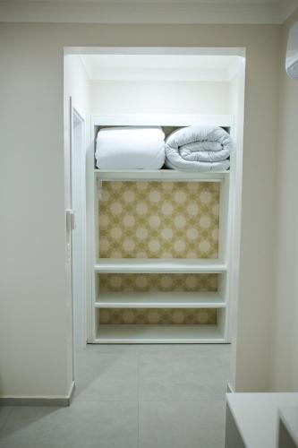 a walk in closet with white shelves and towels at HOTEL HPR in Vitorino