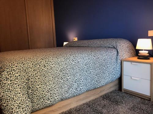 sypialnia z łóżkiem i stołem z lampą w obiekcie Costa Da Morte Deluxe w mieście Malpica