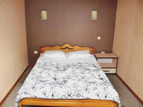 een slaapkamer met een bed en twee nachtkastjes bij Guest House Pid Dubom in Lviv