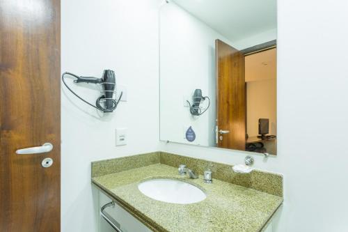 a bathroom with a sink and a mirror at BHomy Jardins Poucos metros da Paulista NO1712 in São Paulo