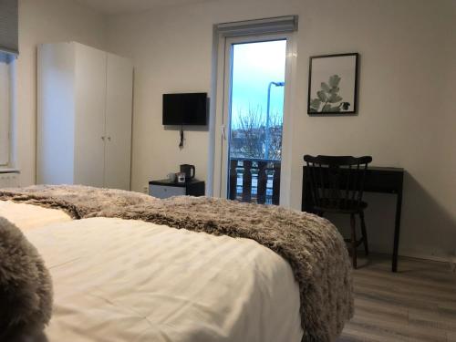 a bedroom with a bed and a desk and a window at Mimosa Hotel in Valkenburg