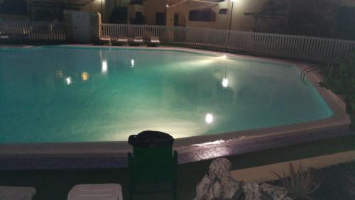 una gran piscina por la noche con luces. en BEAUTIFUL SMALL APARTAMENT, en Costa Calma