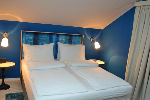 a blue room with a bed with white pillows at Panonija in Kotor