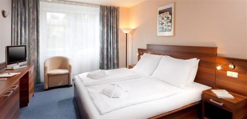 Habitación de hotel con cama y TV en Exclusive HOTEL Lipno Wellness & SPA, en Frymburk