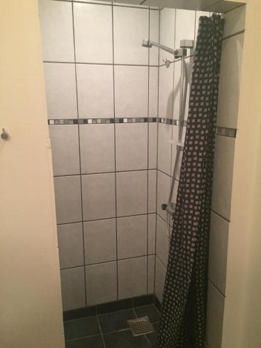 a shower with a shower curtain in a bathroom at Lykkebjerg in Varde