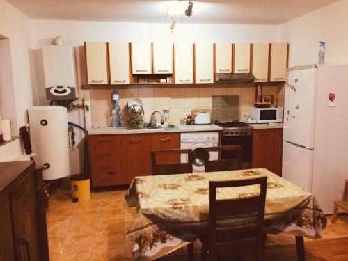 una cucina con un tavolo e un frigorifero bianco di Villa Melania ad Azuga