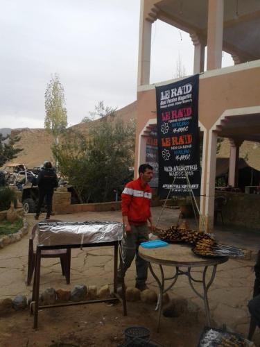 a man standing next to a table in front of a sign at Auberge Camping BOUGAFER Tamtetoucht in Tamtetoucht