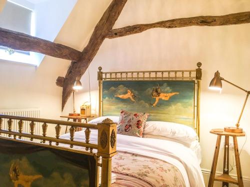 - une chambre avec un lit orné d'une peinture murale dans l'établissement Cotswold Place, à Cirencester