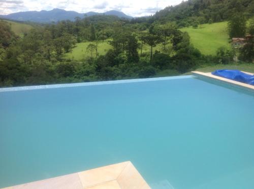 Elle offre une vue sur la piscine et les montagnes en arrière-plan. dans l'établissement Pousada Vale das Araucárias, à Santo Antônio do Pinhal