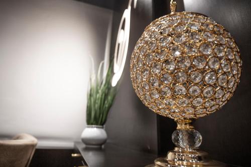 a gold lamp on a table with a vase at Dior Inn Apartment Hotel in Jeddah