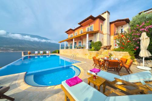 una villa con piscina di fronte a una casa di Villa Poseidon-in winter heated outdoor pool a Kaş