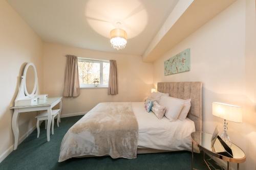 a bedroom with a bed and a table and a mirror at The Broch, 1st Floor, Luxurious City Centre Apartment in Perth