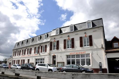 a white building with cars parked in front of it at Hotel du Port et des Bains in Saint-Valery-sur-Somme