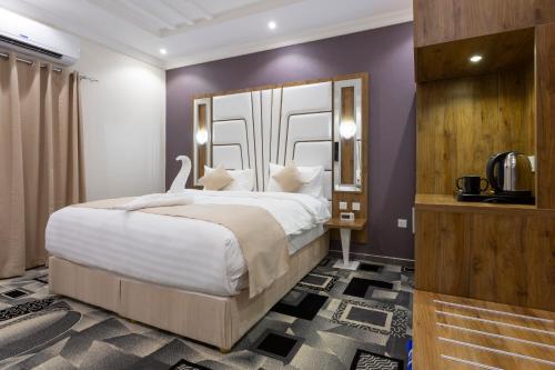 a bedroom with a large bed and purple walls at Dior Inn Apartment Hotel in Jeddah