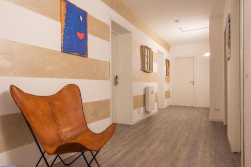 krzesło w korytarzu z obrazem na ścianie w obiekcie Maison Castelli w Bergamo