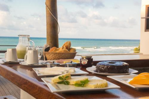 una mesa con comida y vistas al océano en Agora Pousada e Bar, en Pipa