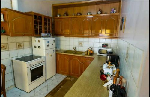 a kitchen with wooden cabinets and a white stove top oven at Rodomelo House with Terrace - 4 Bedrooms in Leonidion