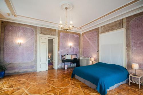 a bedroom with a blue bed and purple walls at Agli incanti in Trieste