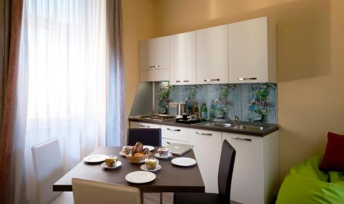 a kitchen with a table with chairs and a small kitchen at Casa da Vito in Bad Kissingen