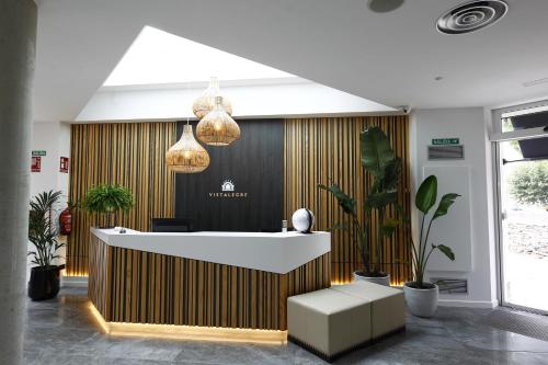 a lobby with a reception desk and potted plants at VISTALEGRE Hotel-Spa in Portomarin