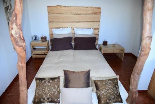 a bedroom with a large bed with pillows at Janela para o Atlântico in Porto Moniz
