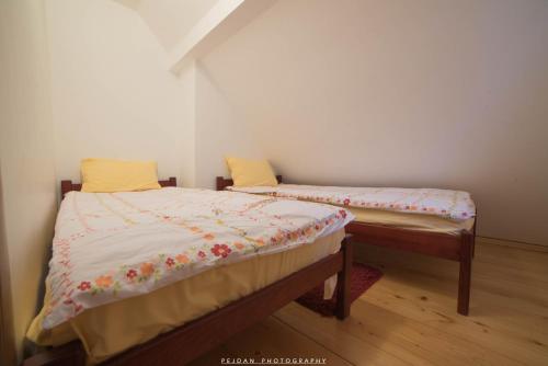two twin beds in a room withweredwered at Snežna Kuća Apartments in Kopaonik