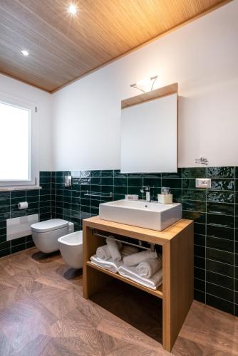 a bathroom with a sink and a toilet and a mirror at Le Terrazze di Bellavista in Su Forti