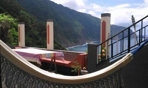 un balcón con hamaca y vistas al océano en Janela para o Atlântico en Porto Moniz