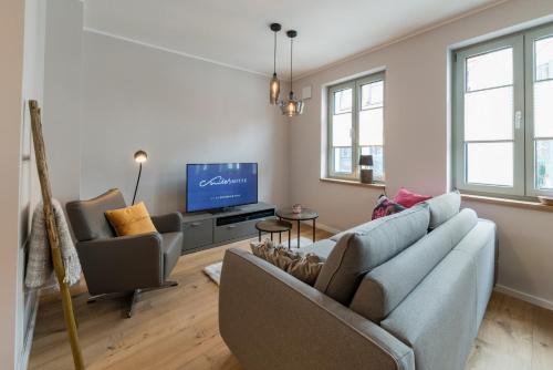 a living room with a couch and a tv at Suites MITTE - Aparthotel in Eisenach