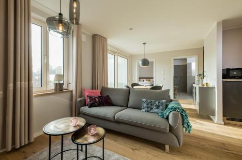 a living room with a couch and two tables at Suites MITTE - Aparthotel in Eisenach