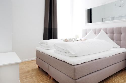 um quarto com uma cama com um cobertor branco em SC 1 Cozy Family & Business Flair welcomes you - Rockchair Apartments em Berlim