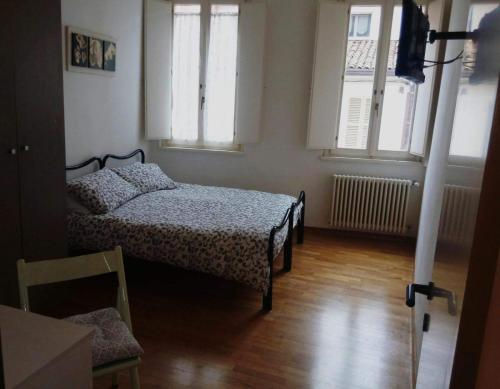 1 Schlafzimmer mit 2 Betten und 2 Fenstern in der Unterkunft Il Vecchio Portico in Cesena