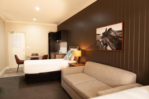 ein Hotelzimmer mit einem Bett und einem Sofa in der Unterkunft Nightcap at Archer Hotel in Nowra