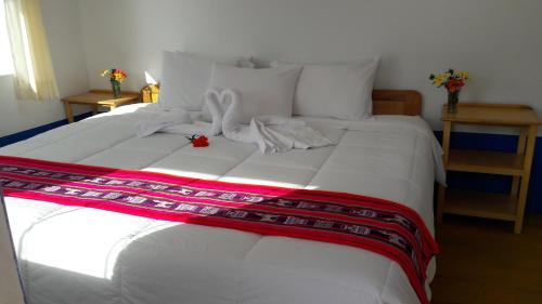 a large white bed with a ribbon on it at Amantani Lodge in Amantani