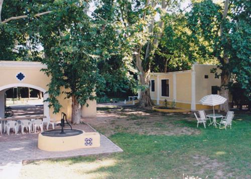 un edificio con una fuente en un patio con mesas y sillas en Casa Huespedes en Hotel Villa Rosarito en Villa del Totoral