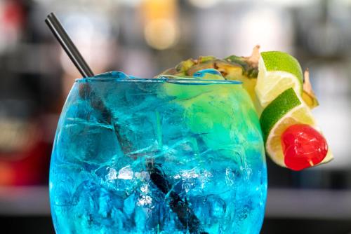 a blue glass with a drink with a cherry and lime at Fairmont Royal Pavilion Barbados Resort in Saint James