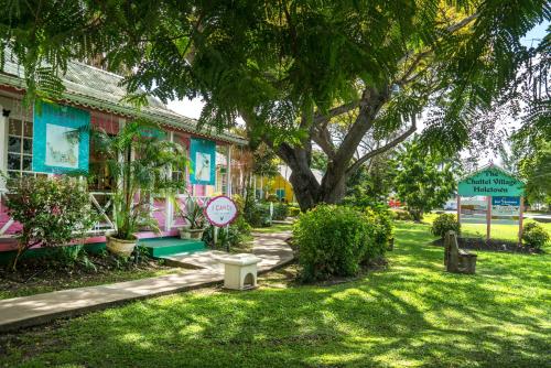 a green yard with a tree and a building at Fairmont Royal Pavilion Barbados Resort in Saint James