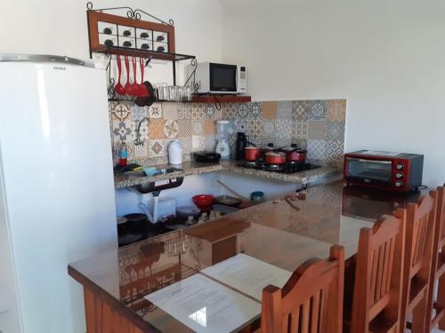 cocina con encimera con mesa y sillas en Casa Lagoa de Geribá - 2 quartos, en Búzios
