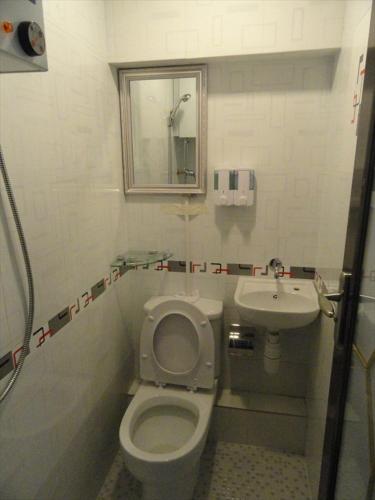 a bathroom with a toilet and a sink at Paris Guest House in Hong Kong