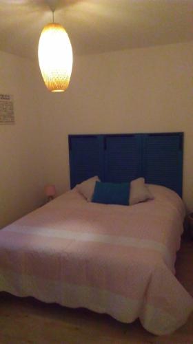 une chambre avec un grand lit avec une tête de lit bleue dans l'établissement les fermes du lacs, à Gérardmer