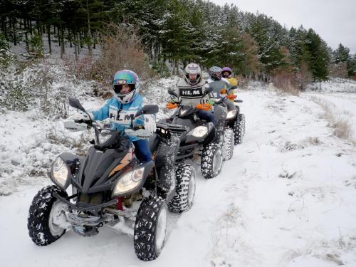 three people riding on atvs in the snow at Posada del Indiano in Cidones
